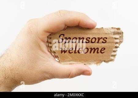 Business and finance. A man holds a cardboard in his hand on which it is written - Sponsors welcome Stock Photo