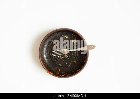 Clay plate dirty after eating on a white background Stock Photo