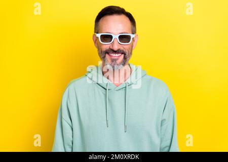 Photo of smiling old retired grey beard mature man wear 3d goggles toothy beaming smile look cinema favorite film isolated on yellow color background Stock Photo