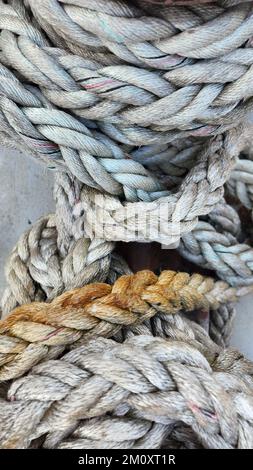 A vertical close-up shot of details of sail rope on the mast of a sailboat. Marine equipment, sea knot, journey Stock Photo