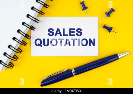 Business and finance concept. On a yellow background lies a notebook, a pen and a business card with the inscription - Sales quotation Stock Photo