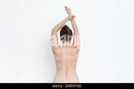 Women's body with kinesio tape on the back. Kinesiology taping concept. White background Stock Photo