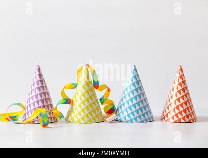 Paper party birthday hats and streamers on white background with copy space Stock Photo