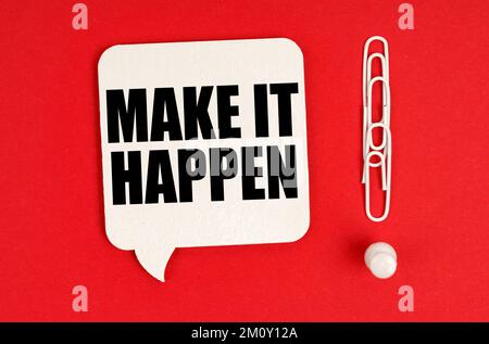 Business concept. On a red background, paper clips are an exclamation mark and a thought plate with the inscription - MAKE IT HAPPEN Stock Photo