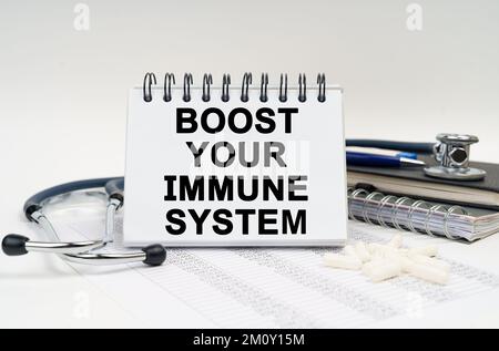 Medicine and health concept. On the table is a stethoscope, a diary and a notebook with the inscription - Boost your Immune System Stock Photo