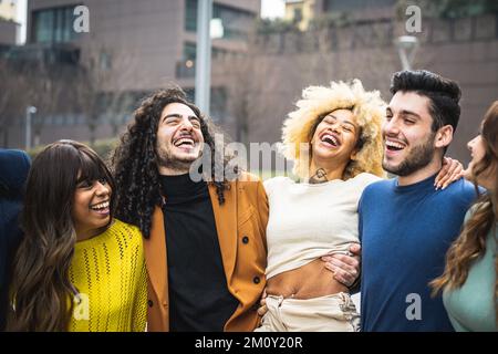 multicultural group of friends walking and having fun together, millennials people smiling and laughing in city context, social diversity people from Stock Photo
