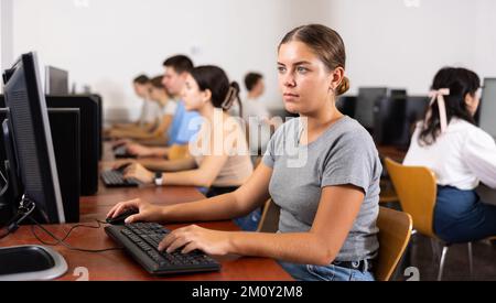 Concentrated female student using PC and studying computer science in ...