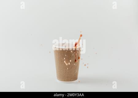 Paper cup with hot drink with splash. White background. Coffee, latte, cappuccino, cocoa. Disposable  paper cup. Recycling and eco friendly concept. Stock Photo