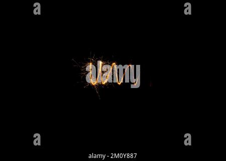 Fire spiral with sparks on a black background. New Year's abstraction with sparklers. Stock Photo