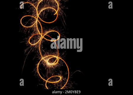 Sparks of Bengal lights on a long exposure. Christmas lights on a black background. Stock Photo