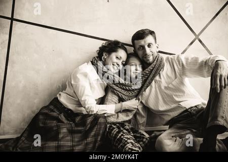 family with Christmas gifts sitting in a cozy living room. black and white photo Stock Photo