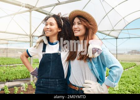 Maintaining their farms long-term sustainability. two young women looking thoughtful while working on a farm. Stock Photo