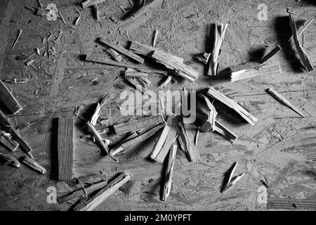 Black and white construction background, wooden sawdust and rolling pins lie on the floor from the osb plate, top view Stock Photo