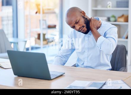 I cant seem to get a break today. a young businessman suffering from back pain in a modern office at work. Stock Photo