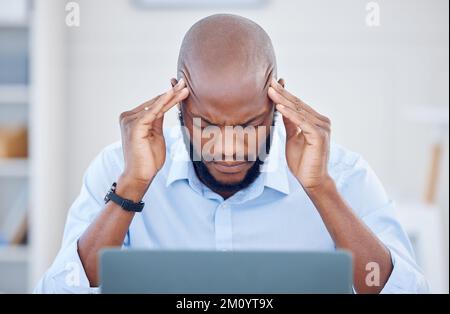 Its just so overwhelming. a young businessman suffering from a headache at work. Stock Photo