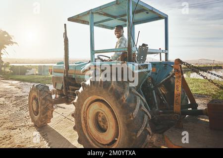 You learn something new everyday when youre working with plants. a young farmer driving a tractor on a farm. Stock Photo