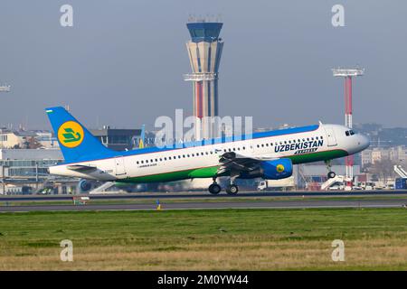 Uzbekistan Airways Express Airbus A320 landing at Tashkent Airport. Aircraft of Uzbekistan Express with Tashkent air traffic control ATC tower behind. Stock Photo