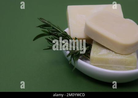 close up of handmade soap bars on white soap tray, green background Stock Photo