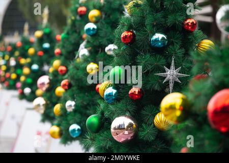 Colourful close up view of Christmas tree decorations with Christmas balls and stars display at an outdoor venue. Singapore Stock Photo