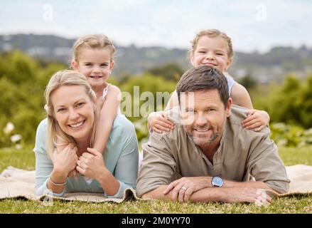 Life is beautiful. Its about giving. Its about family. a family laying on the floor in a park. Stock Photo