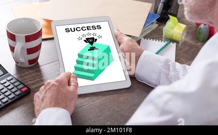 Success concept shown on a tablet held by a man Stock Photo