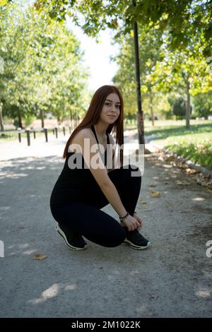 Young woman sitting on skateboard Stock Photo