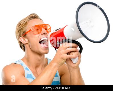 Its party season. a handsome young man standing alone in the studio and using a megaphone. Stock Photo