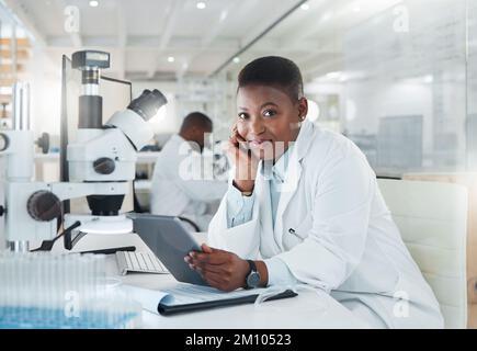 Changing the world one experiment at a time. a young scientist using a digital tablet while working in a lab. Stock Photo