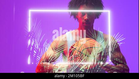 Portrait of biracial player with afro hair holding basketball by illuminated rectangle and plants. Composite, copy space, sport, competition, illustra Stock Photo