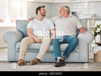 The only rock I know that stays steady. a father and son sitting on the sofa at home. Stock Photo