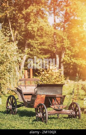 Decorative Yard Wagon On Summer Lawn. Bright Sunny Day. Gardening And Housekeeping. Vintage Cart On Summer Sunny Day. Garden Decoration Concept Stock Photo