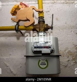 Piggy bank standing to a electricity meter with a 10 Euro bank note ...