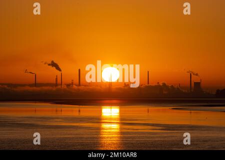 Stanlow Oil Refinery, Ellesmere Port, England, UK. 9th Dec 2022. The sun rises this Friday morning over the refinery, during the continued spell of harsh cold weather, a time when many are struggling with rising energy bills and costs of living. Credit: Callum Fraser/Alamy Live News Stock Photo