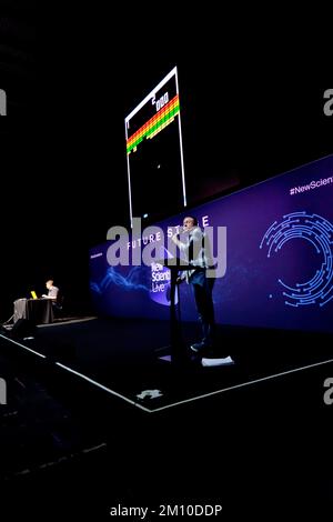 Steve McNeil assisted by Rob Sedgebeer, give a live demonstration of the  evolution of videogames, with the  audience  participating, via their  smartphones, on the Future Stage, at New Scientist Live 2022 Stock Photo