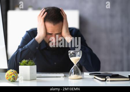 Late Invoice And Billing Deadline With Hourglass At Desk Stock Photo
