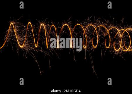 Spiral lights with sparks on a black background. Christmas lights on a long exposure. Stock Photo