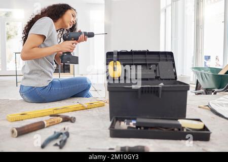 I like to keep busy in my spare time. a woman using a cordless drill while busy renovating. Stock Photo