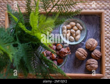 A variety of nuts in bowls from top view. Walnuts, hazelnut, peanut and pine nuts, mix selection. Healthy fitness super food Stock Photo