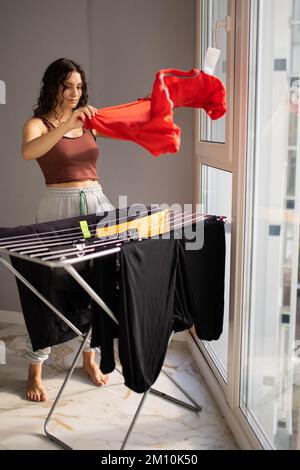 Woman hand washing and hanging up laundry outdoor in a sunny day. Woman  holding a tin bucket of water. Retro style Stock Photo - Alamy