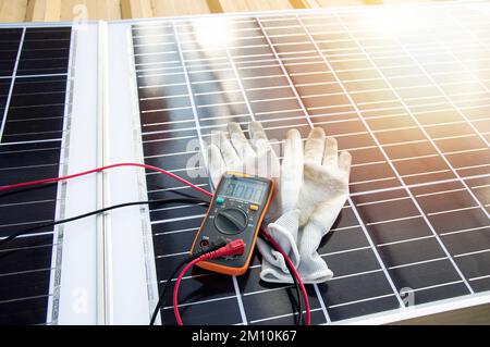 Multimeter and glove pictured on solar panel Stock Photo