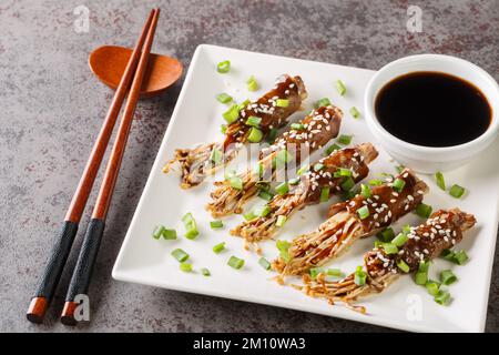 Classic Japanese appetiser made from tasty enoki mushrooms wrapped in thinly sliced beef close-up in a plate on the table. Horizontal Stock Photo