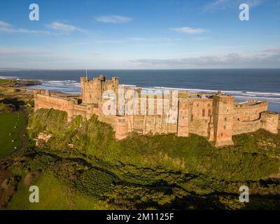 Bamburgh Castle, the ancient capital of the Kingdom of Northumbria, stands on the North East coastline beneath a bright blue sky. Bamburgh Castle is an imposing fort and an example of Norman architecture. Stock Photo