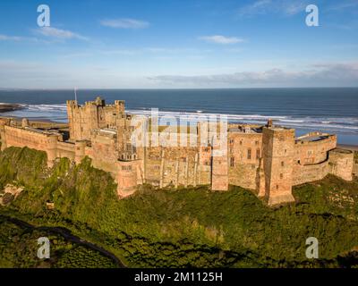 Bamburgh Castle, the ancient capital of the Kingdom of Northumbria, stands on the North East coastline beneath a bright blue sky. Bamburgh Castle is an imposing fort and an example of Norman architecture. Stock Photo