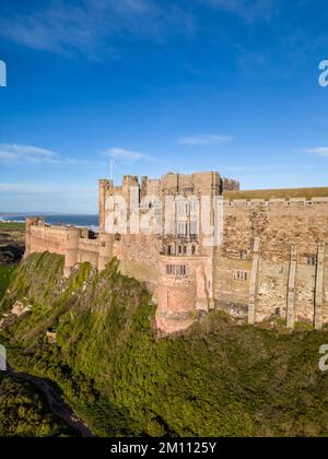 Bamburgh Castle, the ancient capital of the Kingdom of Northumbria, stands on the North East coastline beneath a bright blue sky. Bamburgh Castle is an imposing fort and an example of Norman architecture. Stock Photo