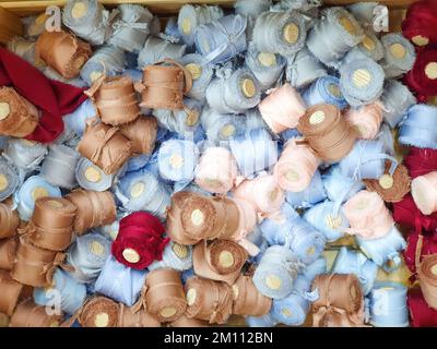 Light blue, pink, beige brown, maroon silk ribbons with wooden spools a lot. Texture background. Closeup, top view. Stock Photo