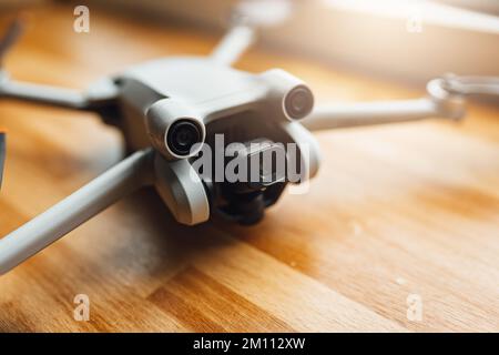 A small size drone placed on a wooden background in front of the window Stock Photo