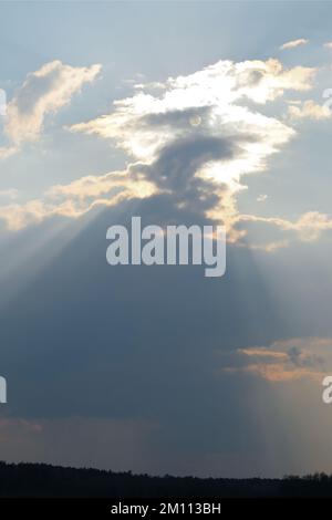The rays of the sun shining from behind the clouds Stock Photo