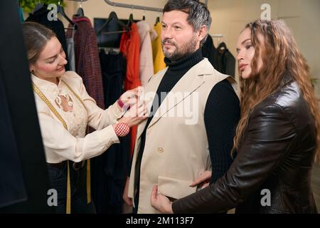 Male client in a sewing studio tries on semi-finished product Stock Photo
