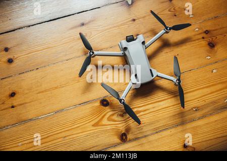 A top view of a small size drone placed on a wooden background Stock Photo