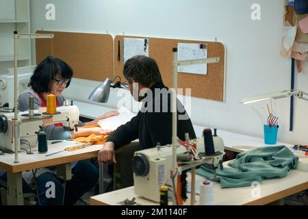 Colleagues, a man and a woman, they consider design sketches Stock Photo